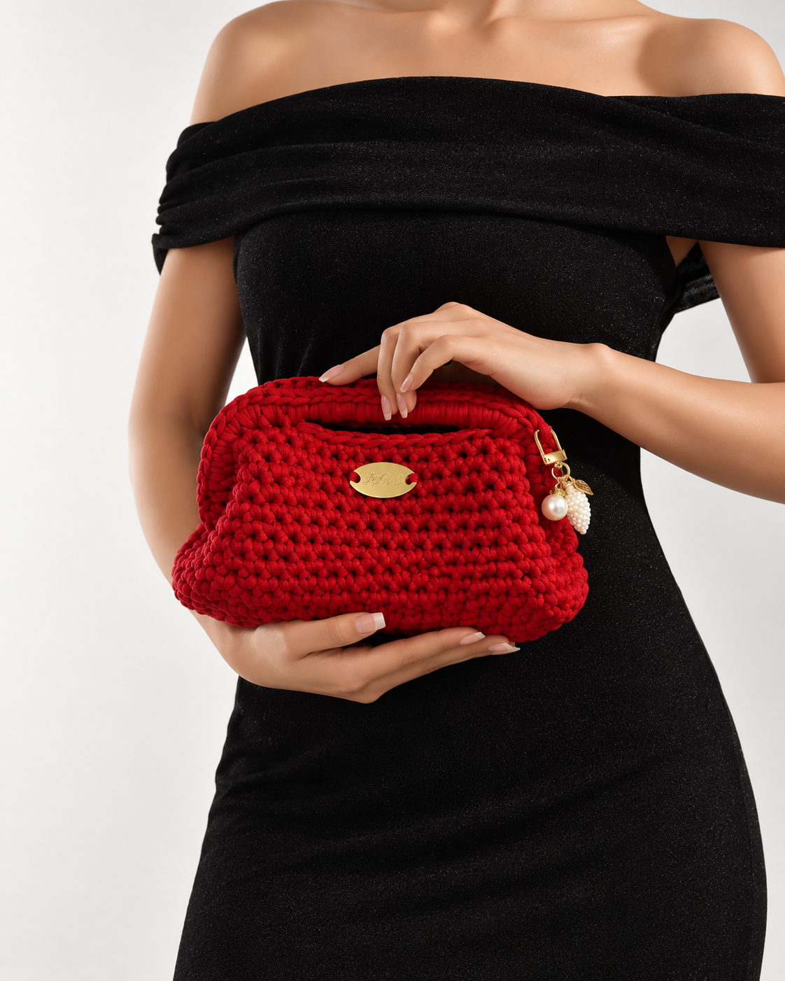 Dame i svart kjole holder en rød håndheklet clutch