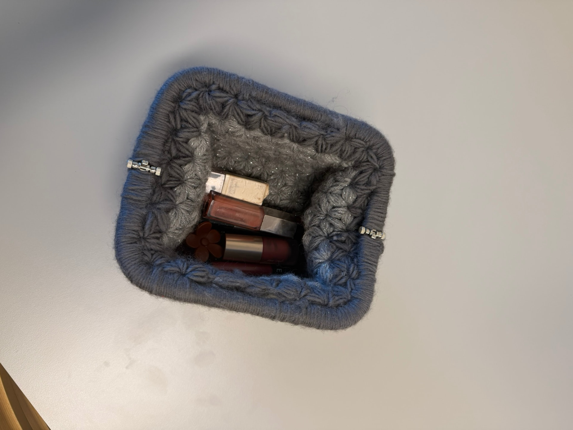 Grå heklet clutch åpen med plass til sminke